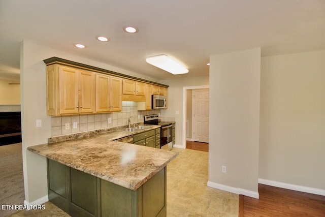 kitchen with light brown cabinets, recessed lighting, a sink, appliances with stainless steel finishes, and backsplash