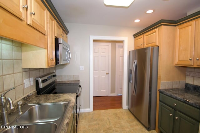 kitchen featuring tasteful backsplash, a sink, baseboards, stainless steel appliances, and recessed lighting