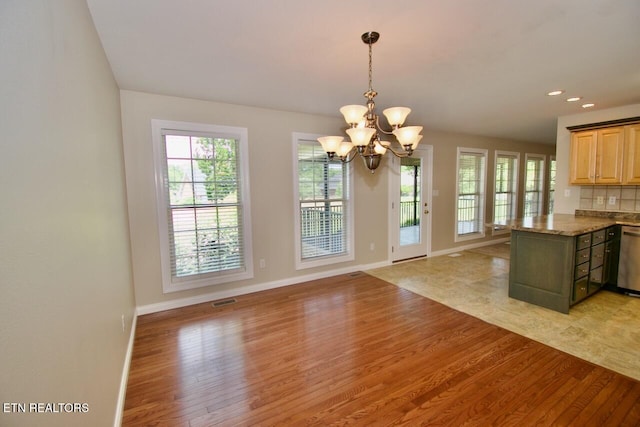 kitchen featuring an inviting chandelier, baseboards, light wood finished floors, and a wealth of natural light