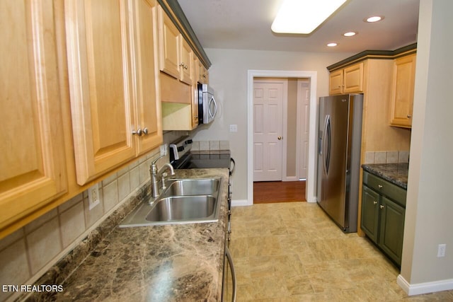 kitchen with appliances with stainless steel finishes, light brown cabinetry, a sink, baseboards, and recessed lighting