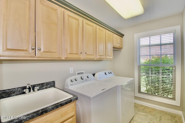 laundry area with a sink, baseboards, cabinet space, and independent washer and dryer