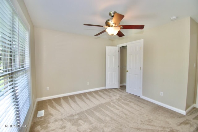 unfurnished bedroom with carpet floors, a ceiling fan, and baseboards