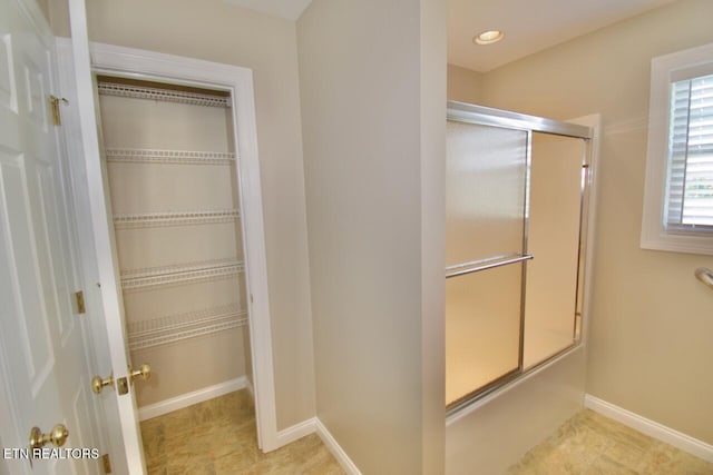 bathroom featuring an enclosed shower, baseboards, and tile patterned floors