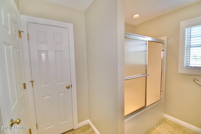 full bathroom with recessed lighting, baseboards, and a shower with shower door
