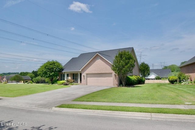 view of front of home featuring an attached garage, fence, a front yard, and concrete driveway