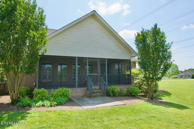 view of front facade featuring a sunroom, a patio area, and a front lawn