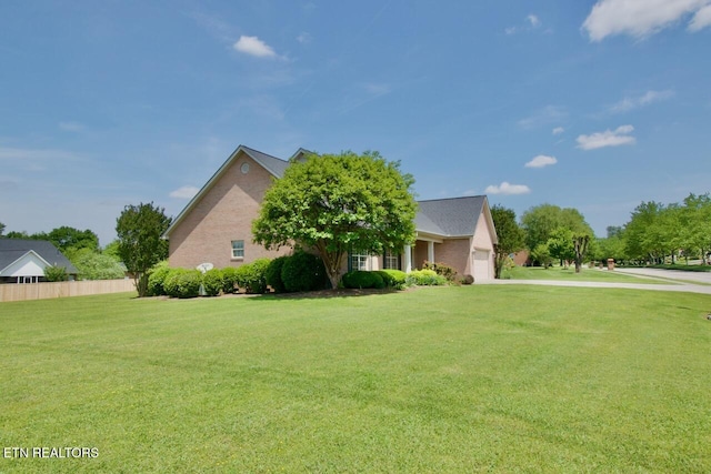 view of home's exterior featuring a lawn, fence, driveway, and a garage