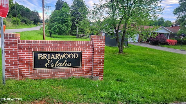 community / neighborhood sign featuring a lawn