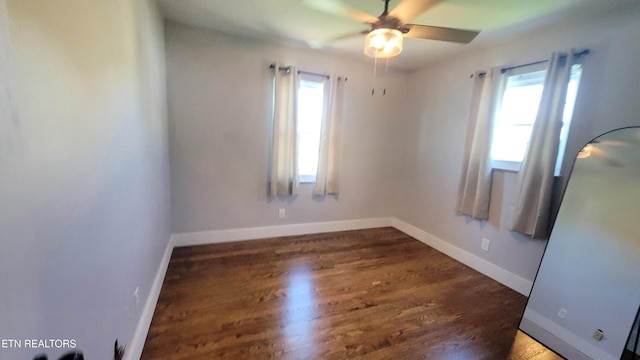 unfurnished room featuring plenty of natural light, a ceiling fan, baseboards, and wood finished floors