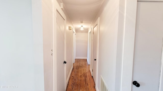 hallway with visible vents and wood finished floors