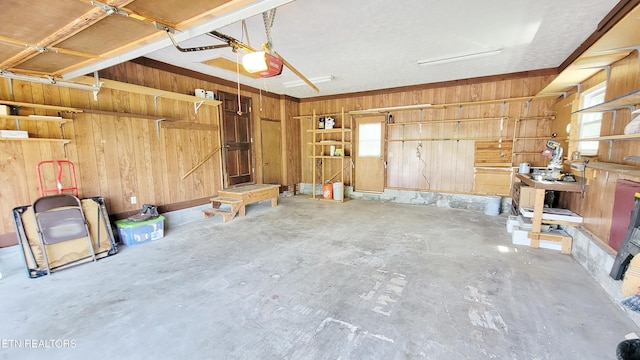garage with a garage door opener and wooden walls