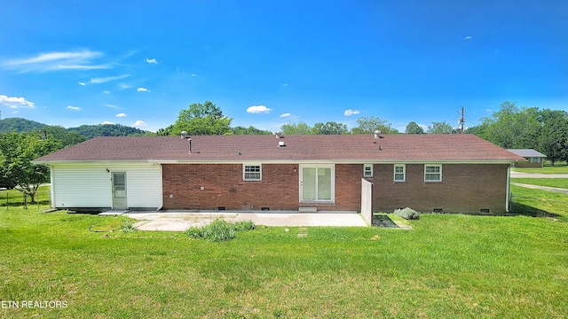 back of house with a lawn, a patio, crawl space, and brick siding