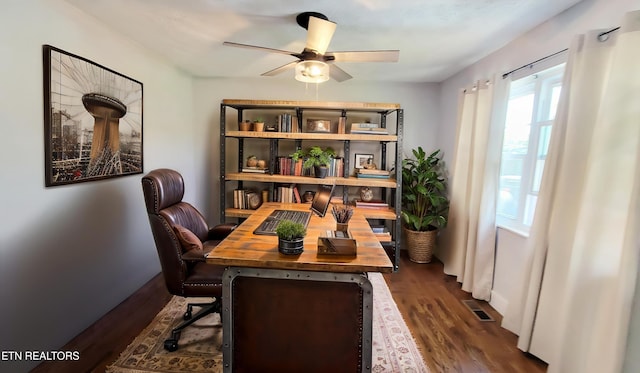office space featuring a ceiling fan, dark wood-type flooring, and visible vents