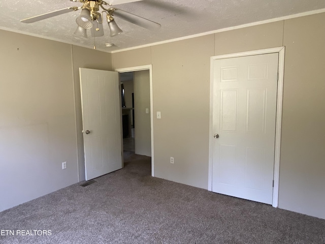 unfurnished bedroom with a textured ceiling, carpet flooring, and ceiling fan