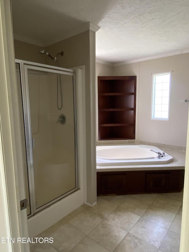 full bathroom featuring tile patterned floors, a shower stall, a bath, a textured ceiling, and crown molding