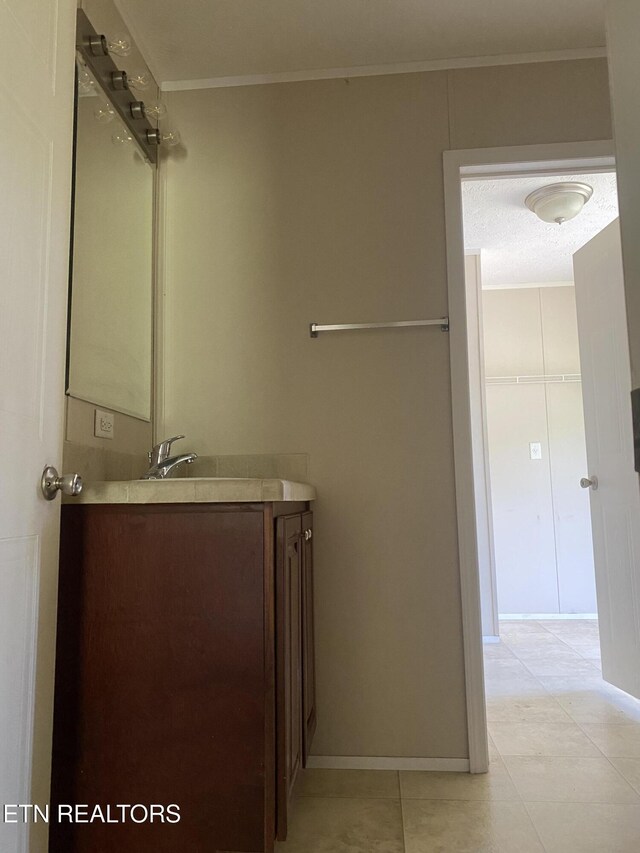 bathroom with tile patterned floors, vanity, and ornamental molding