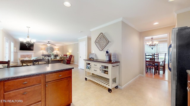 kitchen with a chandelier, dark countertops, freestanding refrigerator, open floor plan, and ornamental molding
