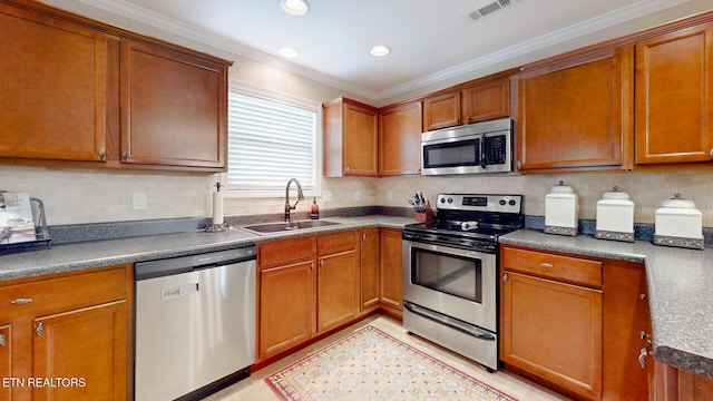 kitchen featuring a sink, stainless steel appliances, tasteful backsplash, visible vents, and ornamental molding