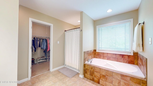 full bathroom with baseboards, a spacious closet, a shower with shower curtain, and a bath