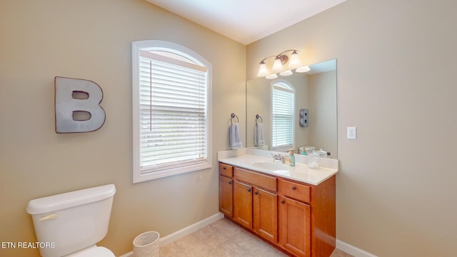 bathroom featuring baseboards, toilet, and vanity