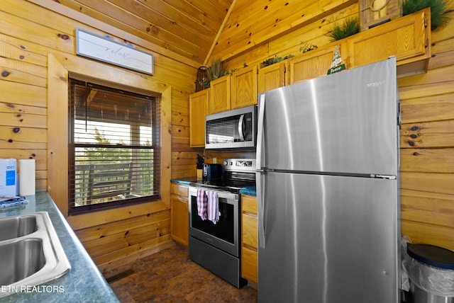 936 Buck Way, Sevierville, TN 37876 - kitchen featuring wood walls, dark countertops, a sink, appliances with stainless steel finishes, and vaulted ceiling
