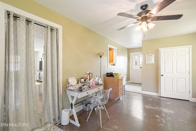 foyer entrance featuring ceiling fan, concrete flooring, and baseboards