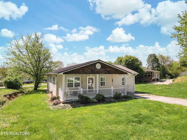 bungalow-style home with a front yard and covered porch