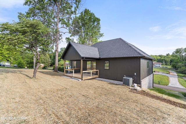 rear view of property with a shingled roof and central AC