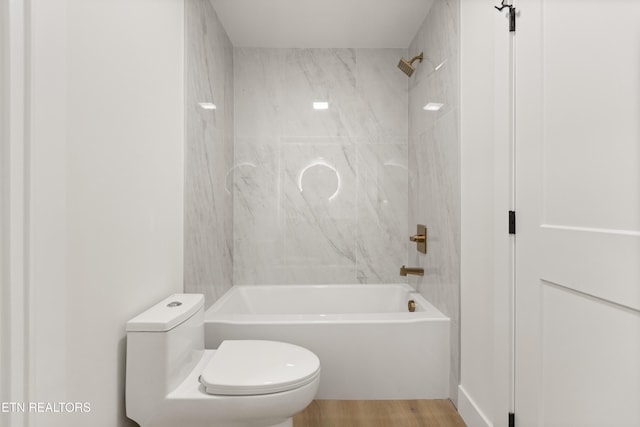 full bathroom featuring toilet, wood finished floors, and shower / washtub combination