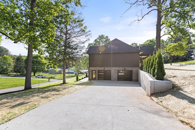 exterior space with brick siding, a garage, and concrete driveway