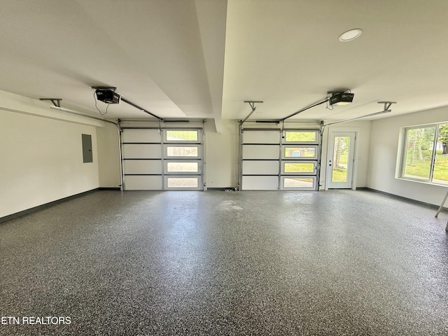 garage with baseboards, a garage door opener, and electric panel
