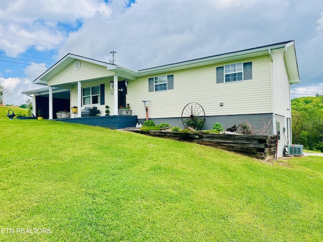 view of front of home featuring covered porch, cooling unit, and a front lawn