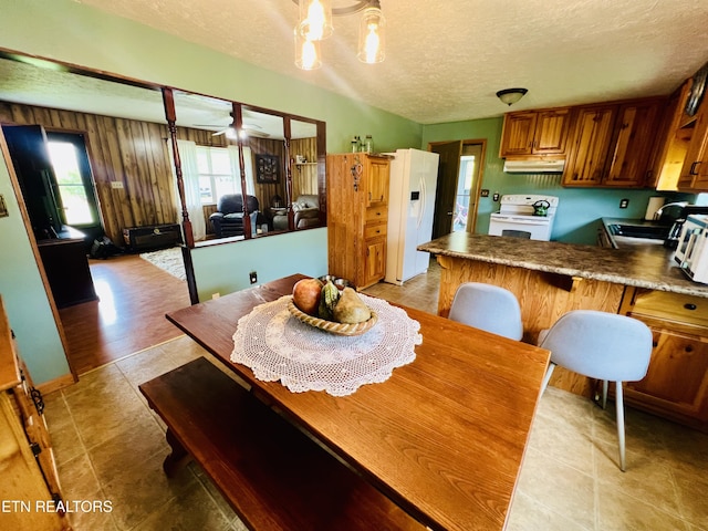 dining space featuring light tile patterned floors, a textured ceiling, and a ceiling fan