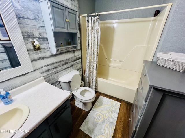 bathroom featuring toilet, vanity, shower / bath combination with curtain, and wood finished floors