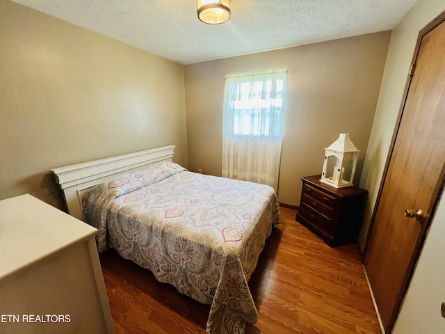 bedroom featuring wood finished floors and a textured ceiling
