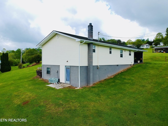 rear view of property featuring a chimney and a lawn