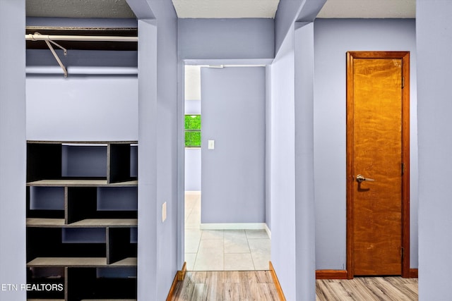 hall with baseboards and wood finished floors