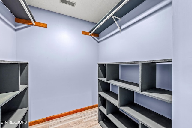 walk in closet featuring visible vents and wood finished floors