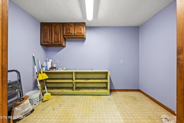interior space featuring a textured ceiling, tile patterned floors, and baseboards