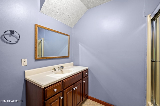 bathroom featuring a textured ceiling, vaulted ceiling, vanity, baseboards, and tile patterned floors