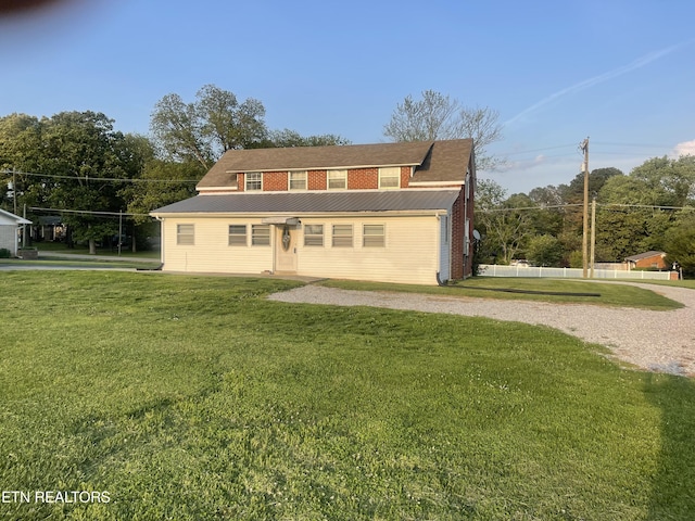 rear view of house with a lawn and metal roof