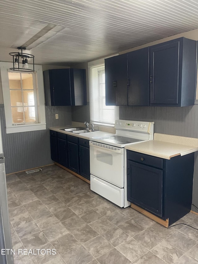 kitchen with a sink, light countertops, white range with electric stovetop, and blue cabinetry