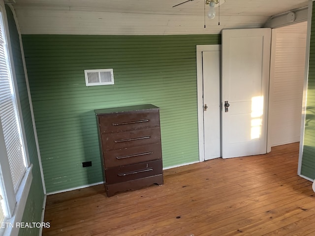 interior space with a ceiling fan and hardwood / wood-style flooring
