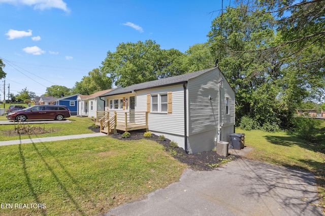view of front of property with a wooden deck and a front lawn