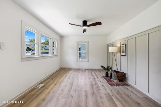 empty room featuring a ceiling fan, light wood finished floors, and visible vents