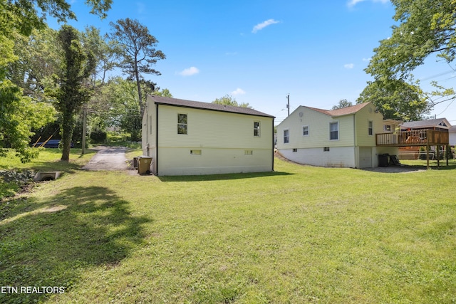 rear view of house with a lawn and a wooden deck