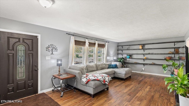 living area with baseboards, a textured ceiling, and wood finished floors
