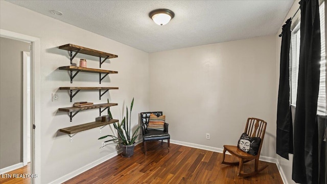 sitting room with baseboards, dark wood finished floors, and a textured ceiling