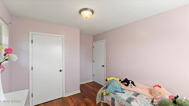 bedroom with baseboards and wood finished floors