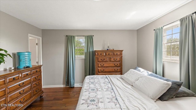 bedroom with baseboards, dark wood-style floors, and multiple windows
